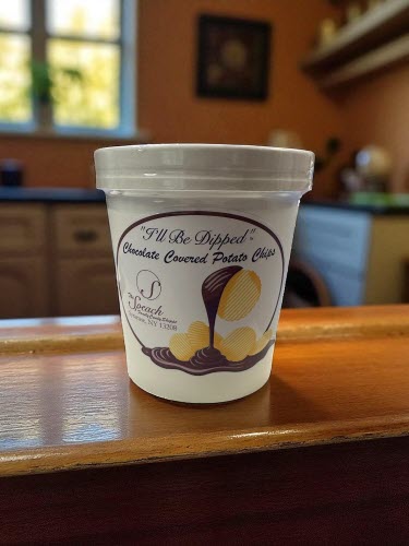 4 oz. container of chocolate covered potato chips on a wooden counter in a kitchen