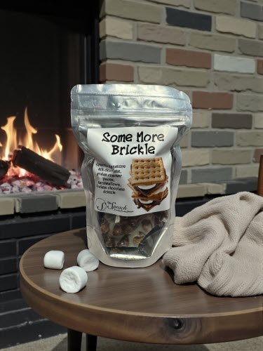 Some More Brickle bag on table in front of a fireplace with marshmallows and a blanket