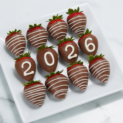 Grad Berries - milk chocolate berries with white chocolate drizzle and number chocolate on four berries in a box on a white marble countertop