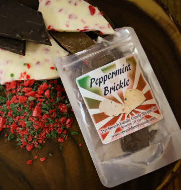 Small bag of Peppermint Brickle open on wooden serving tray with red and green peppermint bits