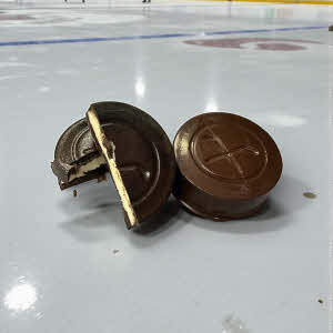Top Shelf Hockey Puck - chocolate hockey puck filled with white ganache on an ice rink